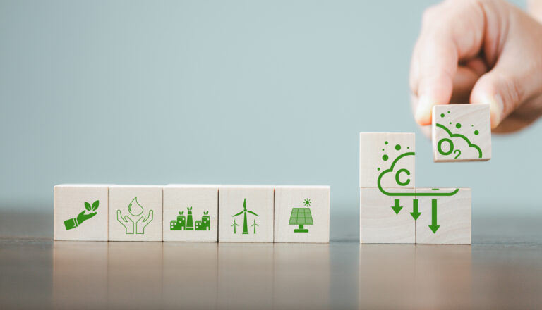 Companies are targeting net zero greenhouse gas emissions. Carbon credit concept.Tradable certificate to drive industry in direction of low emissions in efficiency cost. Wooden cubes with decrease CO2